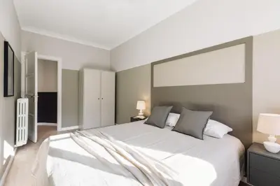 a bedroom with a large white bed with two lamps at Morell - 3 bedroom and office in Eixample Esquerra in Barcelona