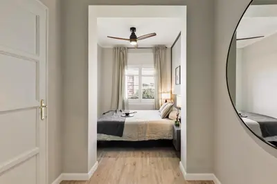 a bedroom with a bed and a chair at Morell - 3 bedroom and office in Eixample Esquerra in Barcelona