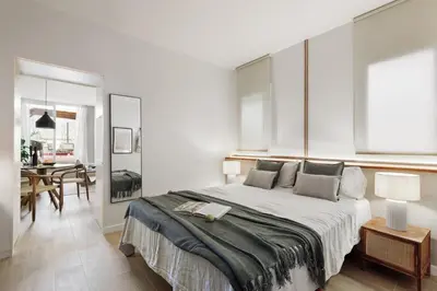 a bed with two lamps and a book on it at Isola - 1 bedroom and terrace in Eixample Dreta in Barcelona