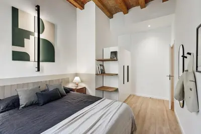 a bedroom with a bed and a table and a window at Xelida - 2 bedrooms and balcony in Sant Antoni in Barcelona