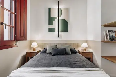 a bedroom with a large bed and white walls at Xelida - 2 bedrooms and balcony in Sant Antoni in Barcelona
