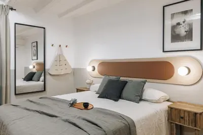 a bedroom with a bed with a headboard with people on it at Acatenango - 2 bedrooms in El Born in Barcelona