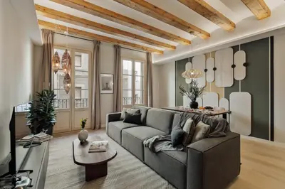 a bedroom with a large bed with a wooden table at Deisis - 2 bedrooms and balcony in Sant Pere in Barcelona