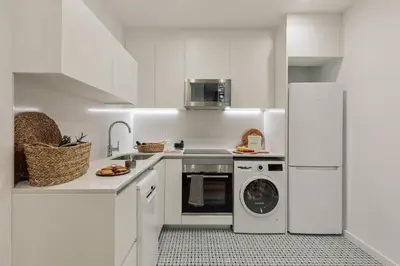 a kitchen with white cabinets and a table and chairs at Pogerola - 2 bedrooms, balcony and terrace in Ciutat Vella in Barcelona