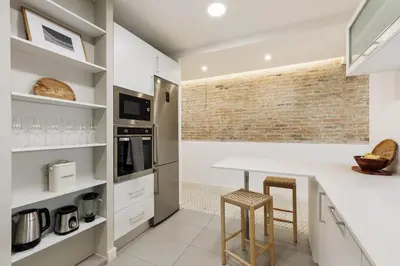 a kitchen with white cabinets and a sink at Tikal - 3 bedrooms and balcony in Sant Gervasi in Barcelona