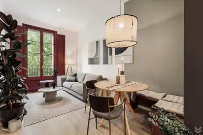 a living room with a table and a plant at Llum - 1 bedroom and balcony in Sant Antoni in Barcelona