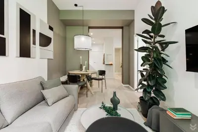 a kitchen with white cabinets and a wooden floor at Llum - 1 bedroom and balcony in Sant Antoni in Barcelona