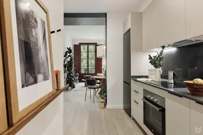 a wooden desk with a lamp and a book at Llum - 1 bedroom and balcony in Sant Antoni in Barcelona