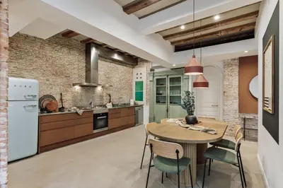 a room with a brick wall and a table and chairs at Galata - 3 bedrooms and terrace in Vila de Gràcia in Barcelona