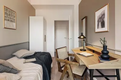 a bedroom with a bed and a table with a chair at Fageda - 2 bedrooms and balcony in Sant Antoni in Barcelona