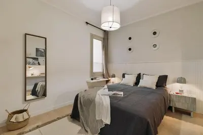 a white bedroom with a large bed and a chair at Rama - 3 bedrooms and terrace in Sant Gervasi in Barcelona