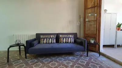 a blue couch with pillows in a living room at Miro Park céntrico 5pax in Barcelona