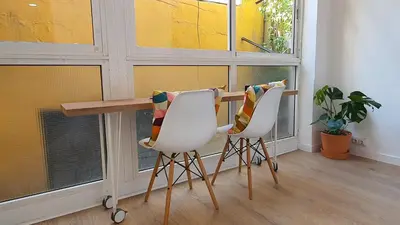 a table and two chairs in a room with windows at Miro Park céntrico 5pax in Barcelona