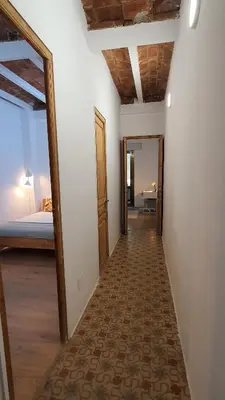 a hallway with a room with a bed and a mirror at Miro Park céntrico 5pax in Barcelona