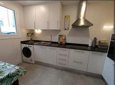 a kitchen with white cabinets and a sink and a stove at Confort y Calma en Barcelona in Barcelona