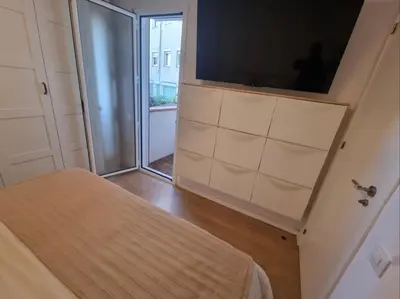 a bedroom with a tv and a sliding glass door at Confort y Calma en Barcelona in Barcelona