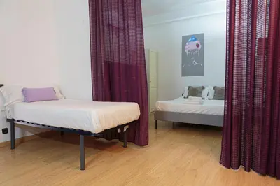 a room with two beds and a mirror at Gracia&Güell Home in Barcelona