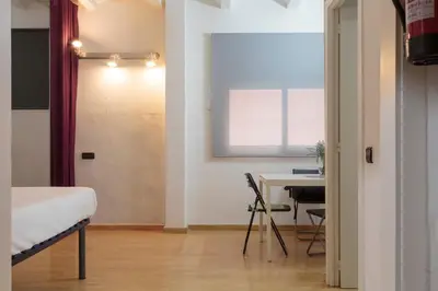 a bedroom with a bed and a desk and a table at Gracia&Güell Home in Barcelona