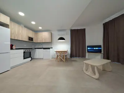 a large white kitchen with a table and a bench at Ca l'Emília, hasta 6 pers, Monistrol de Montserrat in Monistrol