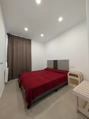 a bedroom with a red bed with a red blanket at Ca l'Emília, hasta 6 pers, Monistrol de Montserrat in Monistrol