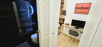 a room with a television and a desk with a television at 2 apartamentos juntos ideal grupos cerca Barcelona in Badalona