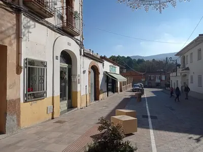 a street in a town with boxes on the sidewalk at Casa rural Cal Farriol in Mediona