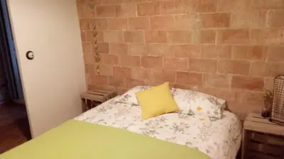 a bed with a yellow pillow on top of it at Casa rural Cal Farriol in Mediona