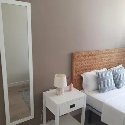 a bedroom with a bed and a table with a lamp at Benet Sitges in Sitges