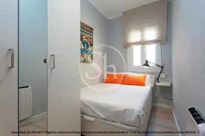 a white bedroom with a bed and a window at Bonito apartamento para 3 en Poble Sec in Barcelona