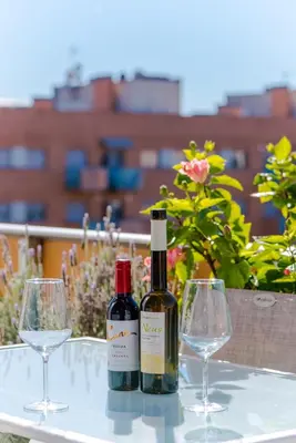 a bottle of wine and two glasses on a table at Glorious Sunny penthouse near the beach in Barcelona