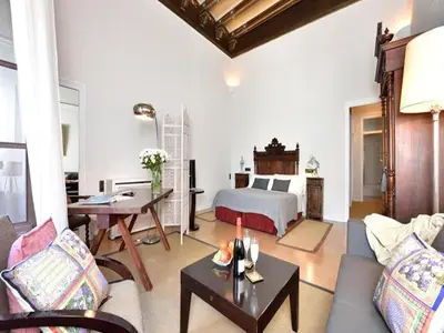a living room with a fireplace and a living room with flowers at Farmhouse in Anoia near Montserrat in Capellades