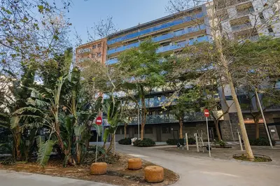 a large building with trees in front of it at Quiet modern 2 bed apartment with Balcony, Pool and Free Parking in Barcelona