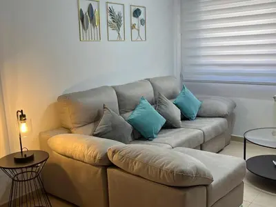a living room with a couch with blue pillows at Holiday near Sitges with private terrace in Vilanova i la Geltrú