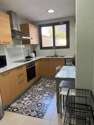 a kitchen with a table and a sink and a table and chairs at Holiday near Sitges with private terrace in Vilanova i la Geltrú