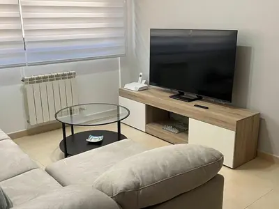 a living room with a couch and a flat screen tv at Holiday near Sitges with private terrace in Vilanova i la Geltrú