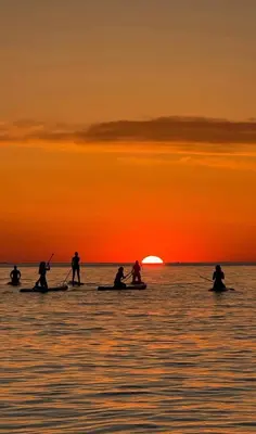 a group of people on kayaks in the ocean at sunset at Barcelona's Gem in Barcelona