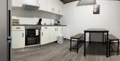 a kitchen with white cabinets and a wooden table at Barcelona's Gem in Barcelona