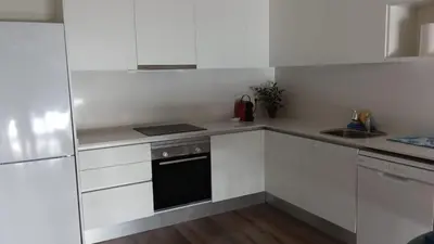 a kitchen with white cabinets and a black oven at Contemporary 2BR with Pool & Gym in Hospitalet de Llobregat