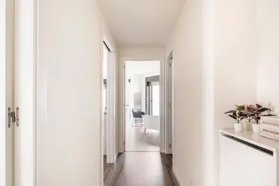 a hallway with white walls and white floors and a hallway with at Contemporary 2BR with Pool & Gym in Hospitalet de Llobregat
