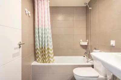 a bathroom with a toilet and a shower curtain at Contemporary 2BR with Pool & Gym in Hospitalet de Llobregat