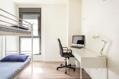 a bedroom with a desk and a bunk bed at Contemporary 2BR with Pool & Gym in Hospitalet de Llobregat