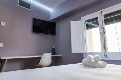 a bedroom with a bed with a tv on the wall at Hotel La Sagrera in Sant Fruitos de Bages