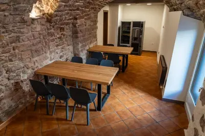 two tables and chairs in a room with a brick wall at Hotel La Sagrera in Sant Fruitos de Bages