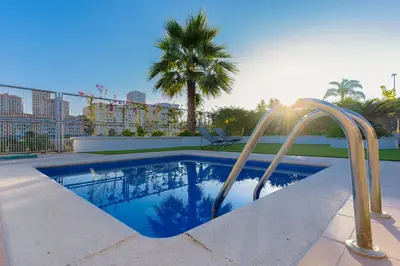 a swimming pool with a stairway leading to a palm tree at Beachy House - Casa en Montgat, Barcelona in Montgat