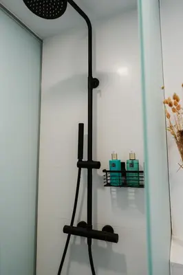 a black floor lamp next to a white wall at Apartaments Casa Padró in Manresa