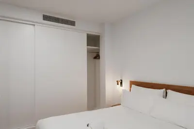 a bedroom with a white bed and a window at Apartaments Casa Padró in Manresa