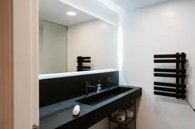 a bathroom with a black sink and a mirror at Apartaments Casa Padró in Manresa