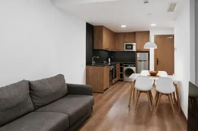 a living room with a couch and a table and chairs at Apartaments Casa Padró in Manresa