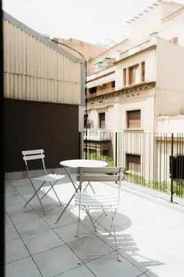 a table and chairs on a balcony with buildings at Apartaments Casa Padró in Manresa