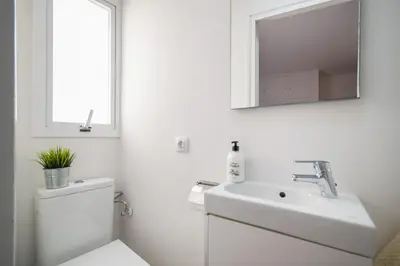 a white bathroom with a sink and a mirror at Sunset Beachfront in Sitges in Sitges